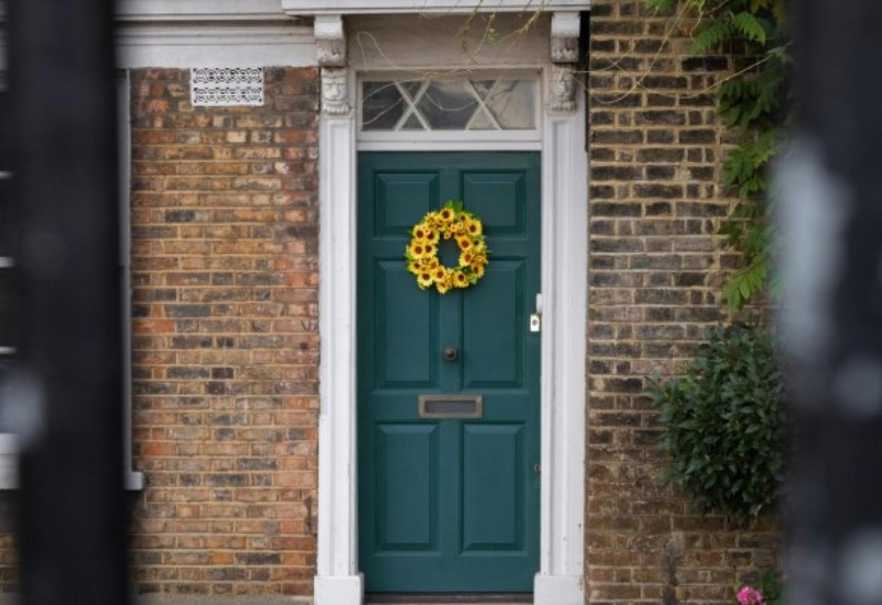 Green front door with yellow wreath