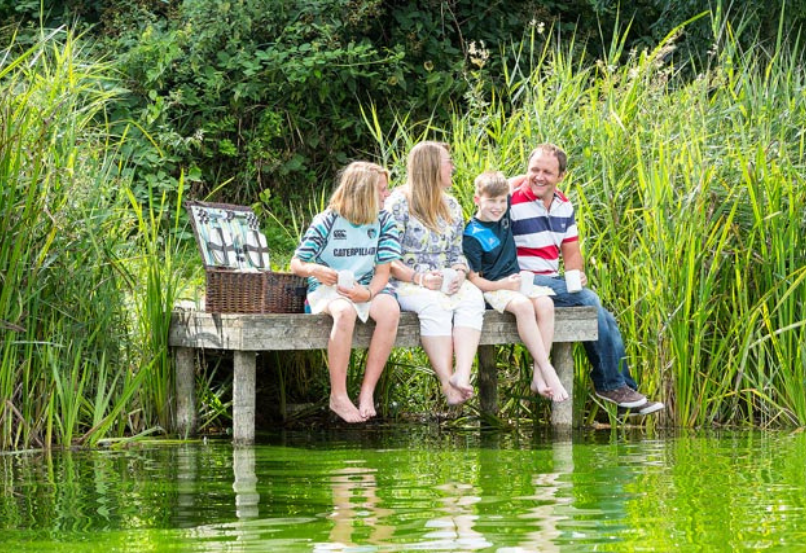 Family sitting on a jetty in countryside